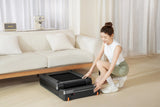 Vrouw schuift KingSmith WalkingPad Z3 Just Walk onder bank in woonkamer