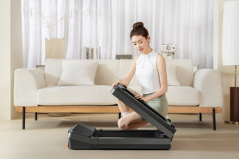 Vrouw klapt KingSmith WalkingPad Z3 Just Walk in bij bank in woonkamer
