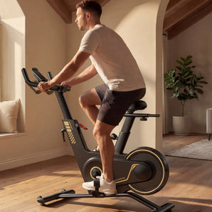 Zijaanzicht van de KingSmith WalkingPad Sprint Bike PB08S hometrainer vrijstaand in de woonkamer terwijl man aan het fietsen is
