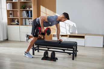 Man traint de rug op een bank met de Kingsmith Adjustable Dumbbells
