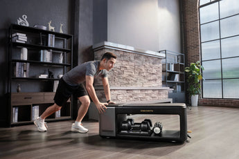 kingsmith-bx2-fitnessbank-verrijdbaar-op-wielen — Man verplaatst Kingsmith BX2 fitnessbank op wielen