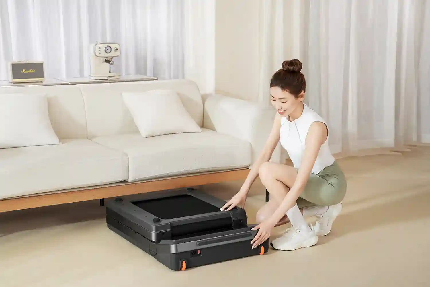 Vrouw schuift KingSmith WalkingPad Z3 Just Walk onder bank in woonkamer