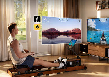 Man roeit op Kingsmith roeitrainer met trainingsvideo op tv